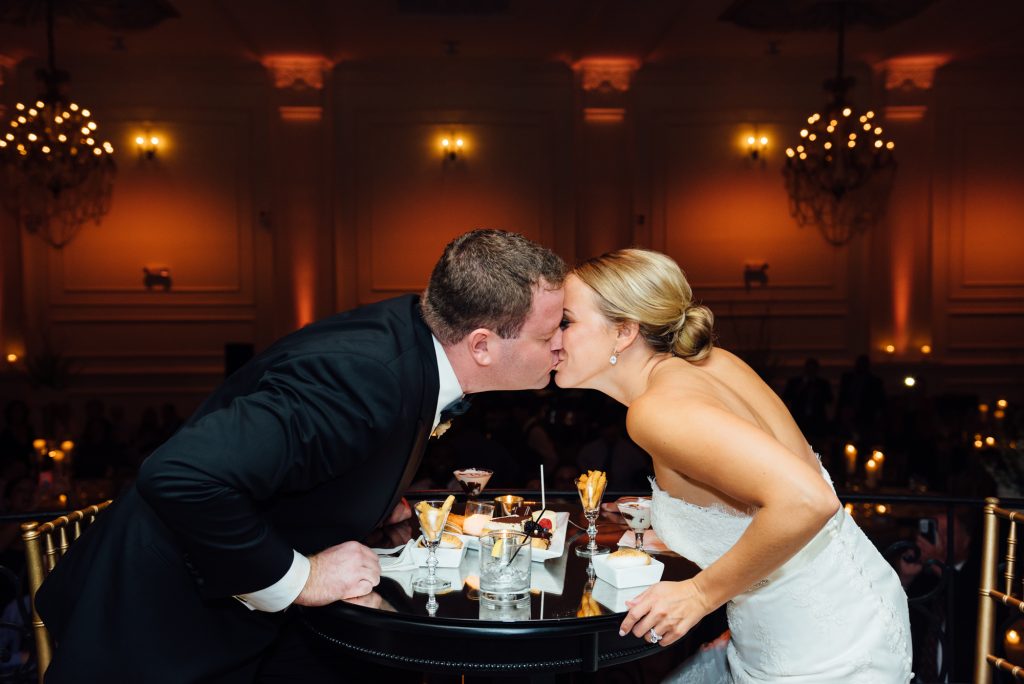 Bride and groom kissing at wedding reception