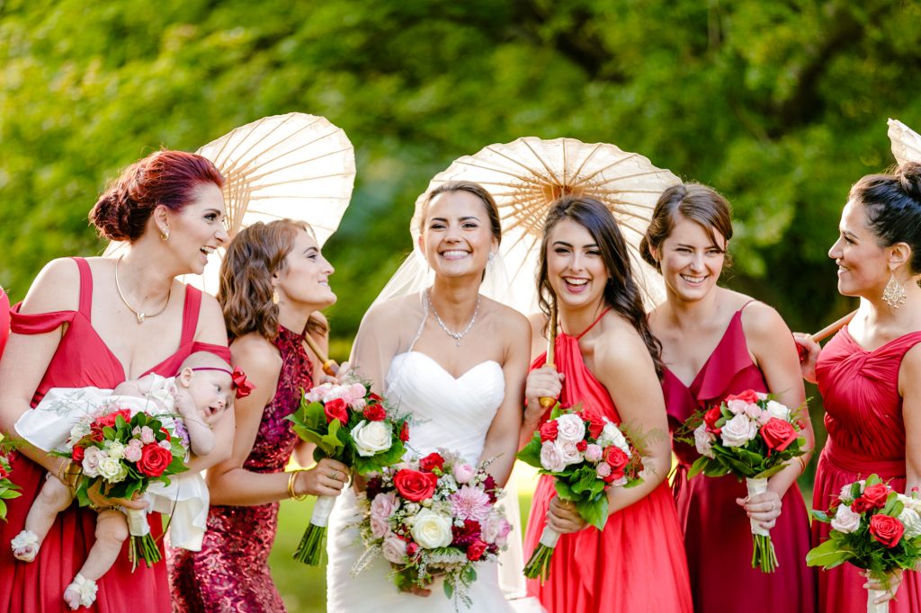 Bride and bridemaids in red dresses smiling