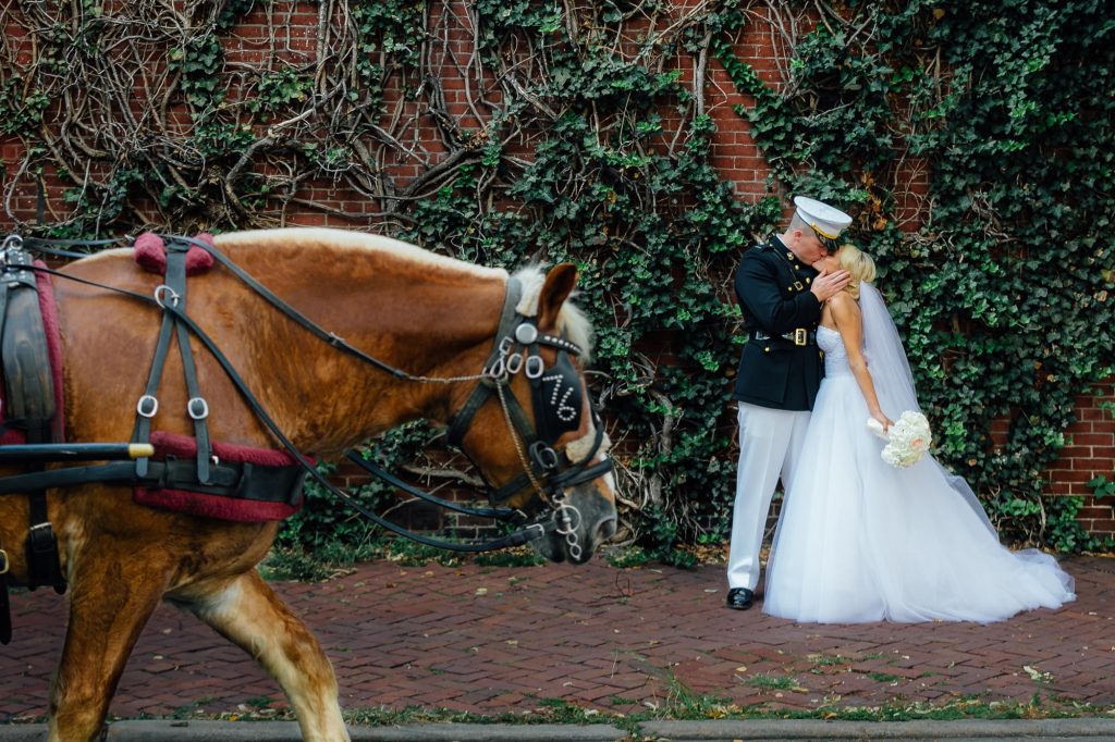 newlywed couple kissing while a horse pass by at rittenhouse square park