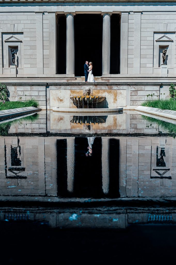 Bride and groom posing in front of Rodin Museum reflection pool