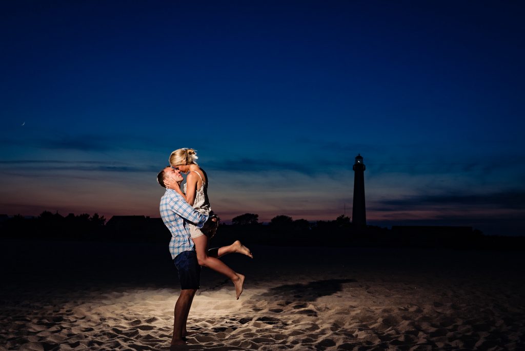couple shares a kiss on the shores of Avalon New Jersey during their beach engagement session