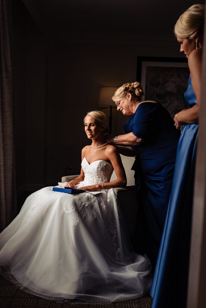 Ritz Carlton Philadelphia Wedding|mother of the bride putting necklace on bride