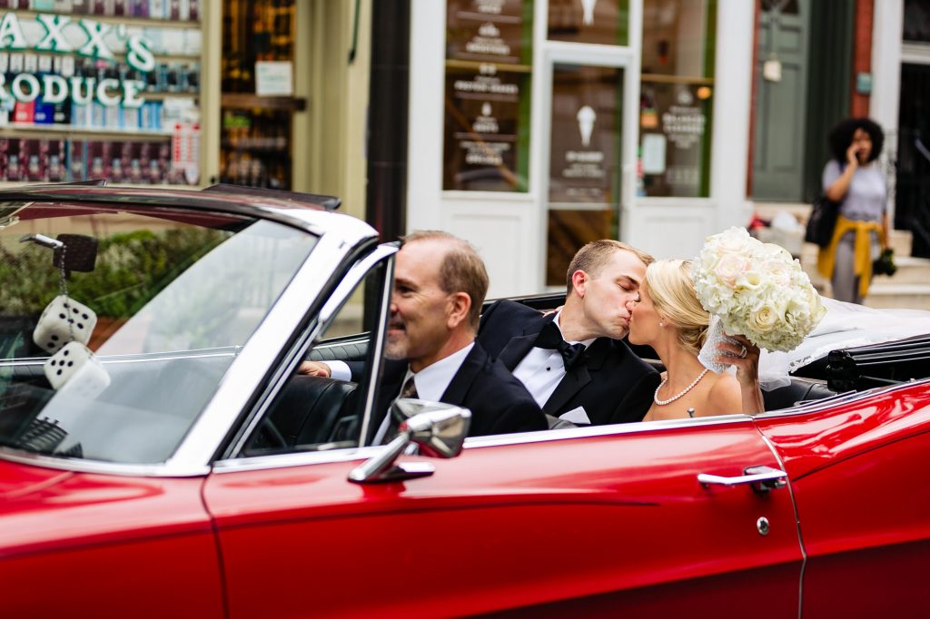 Ritz Carlton Philadelphia Wedding|bride and groom in back seat of red sportscar kissing