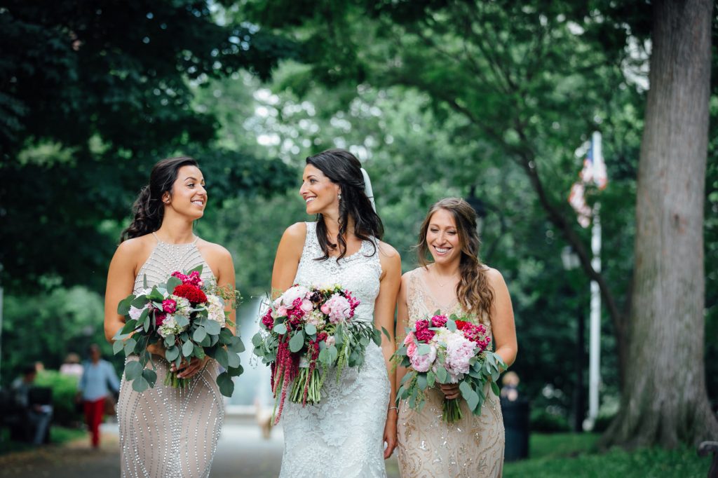 Bride and bridesmaids holding bouquets while walking