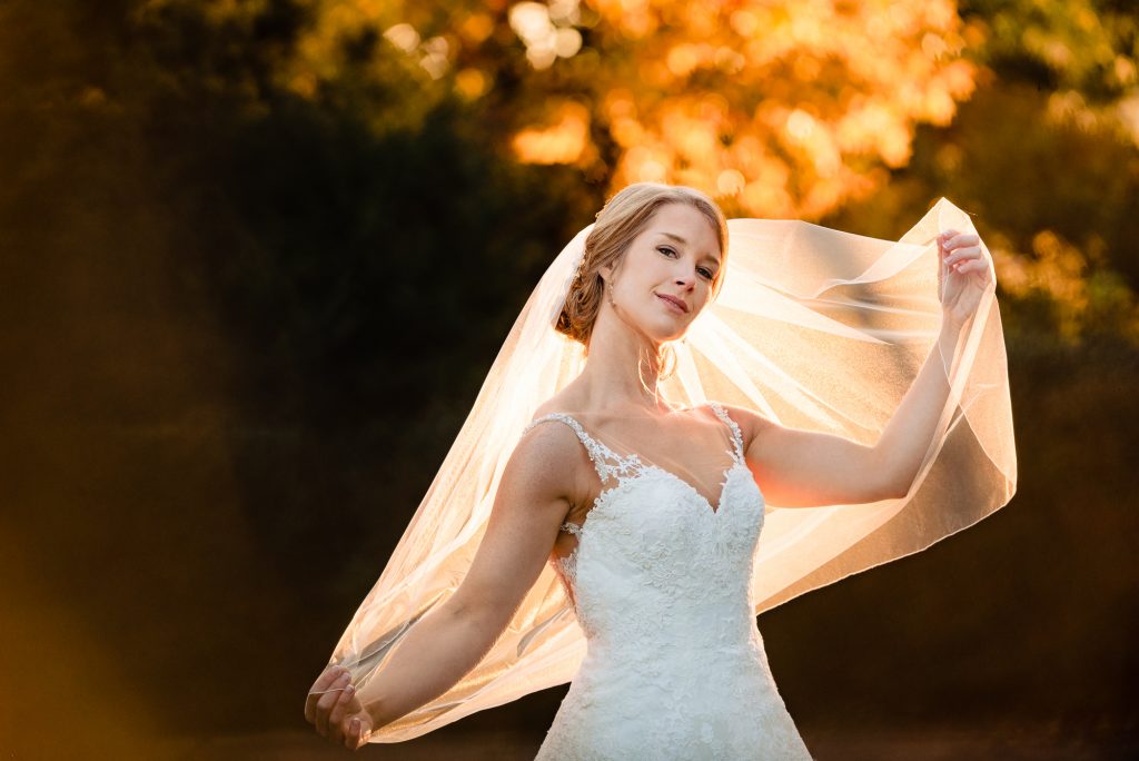 Bride playing with her veil at sunset