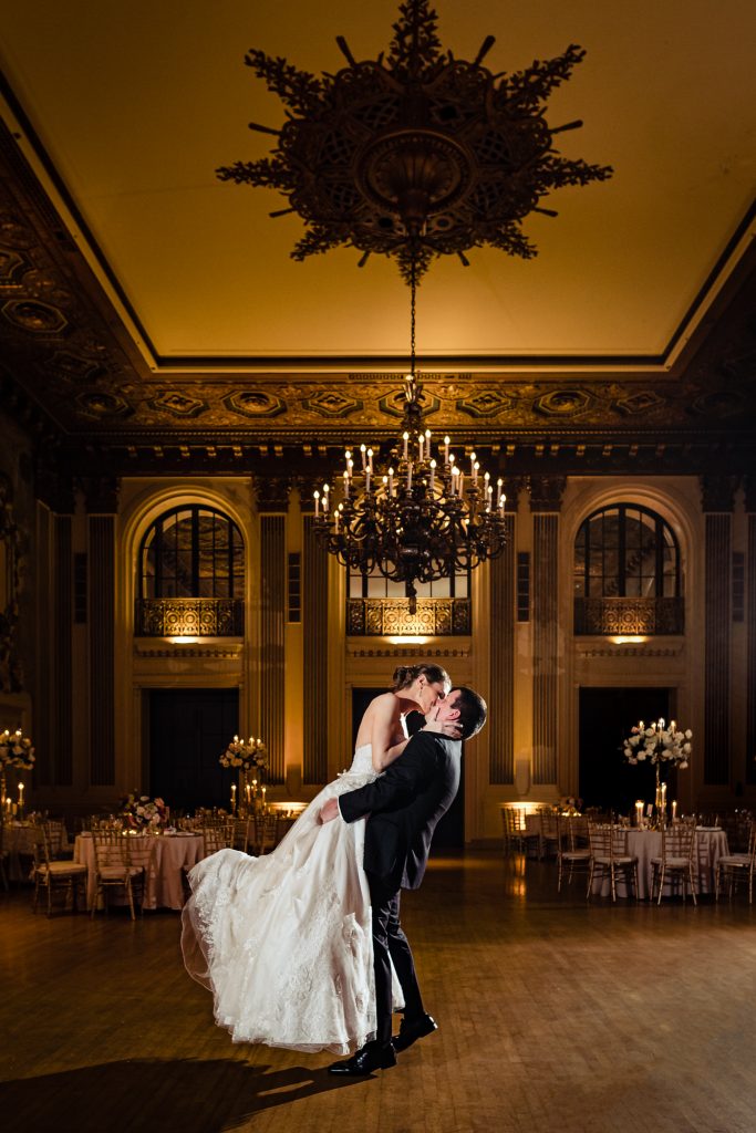 wedding photographer captures the newly wed kissing on the ballroom
