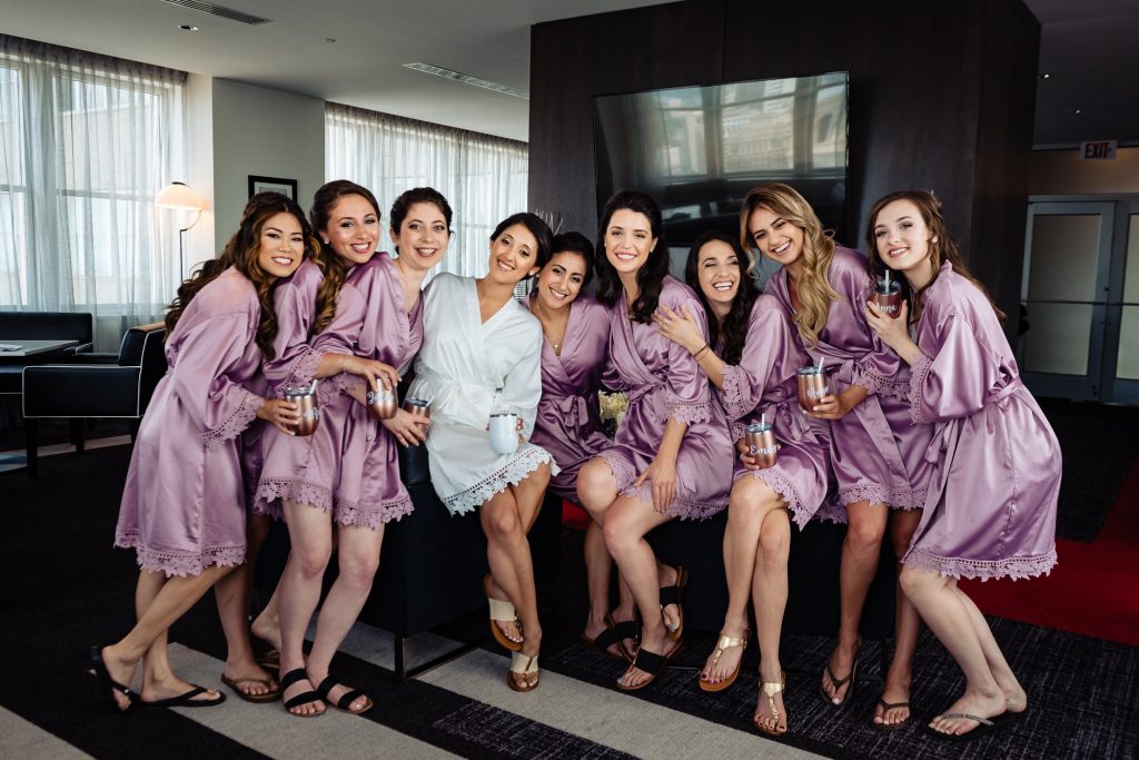 bride with bridesmaids poses in their robes