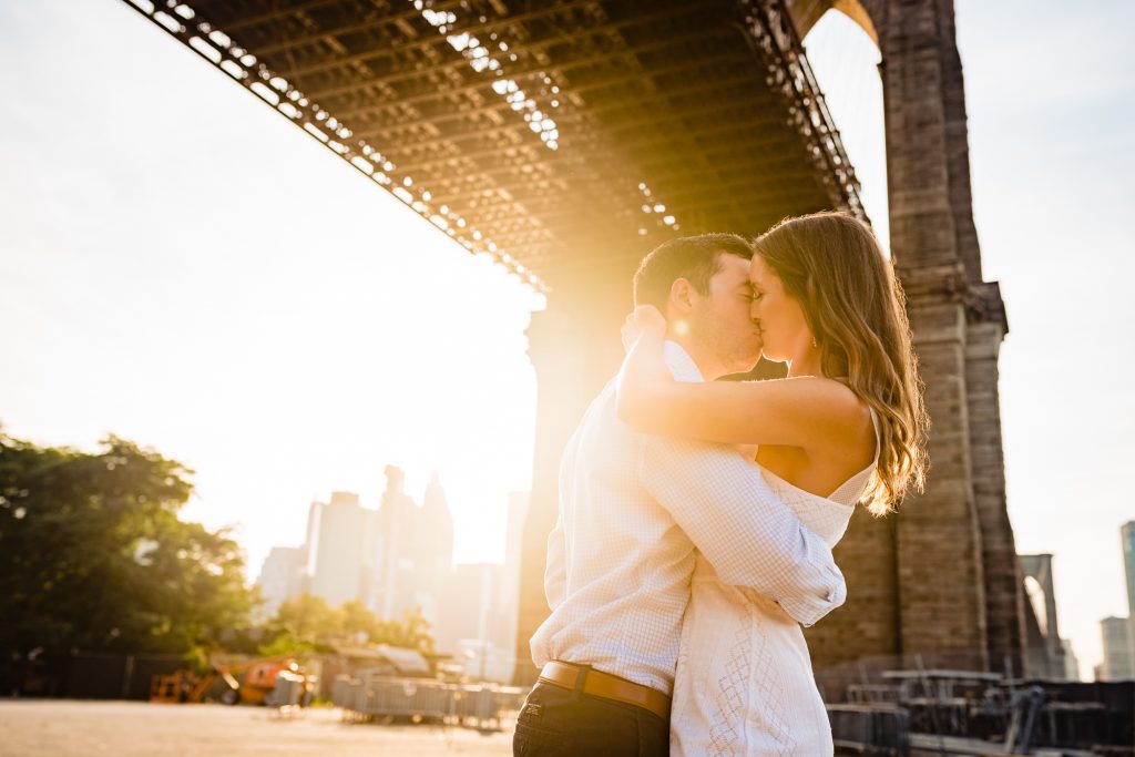 couple shares a kiss during their brooklyn bridge park eshoot