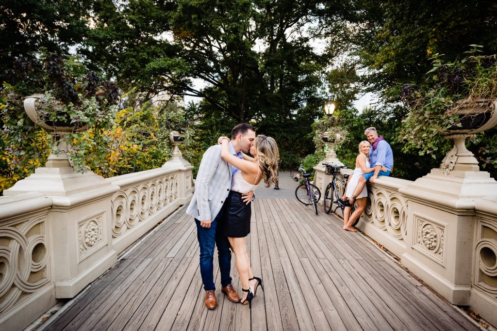 couple kissing on Bow Bridge in central park