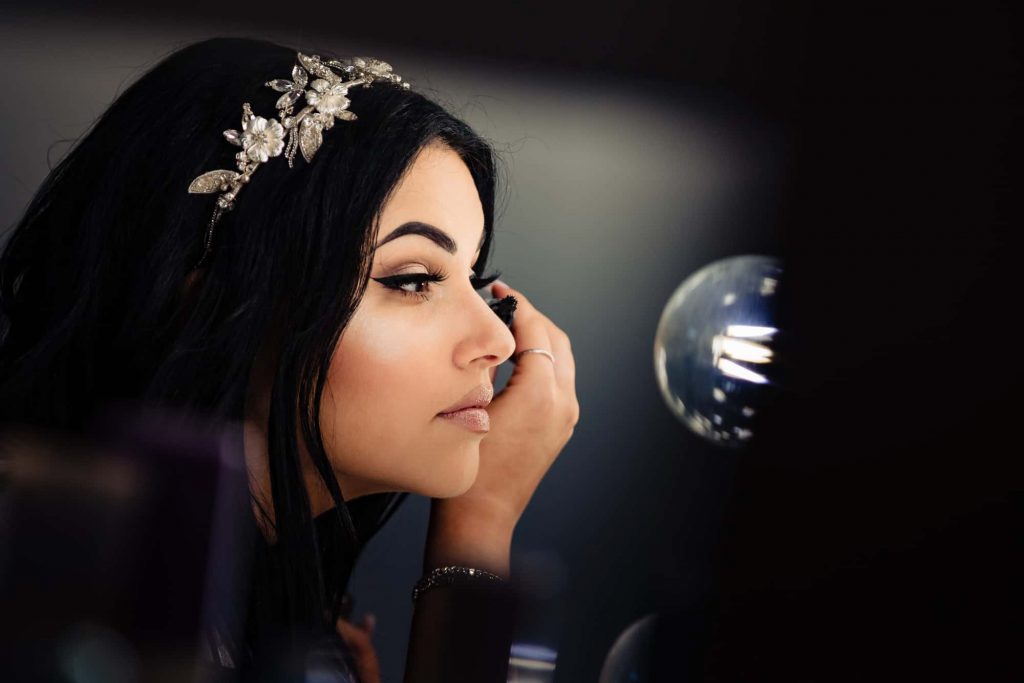 side view of bride fixing her eye makeup