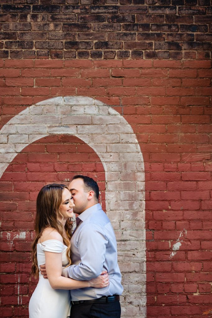 couple shares a kiss during their Brooklyn Bridge park e-session