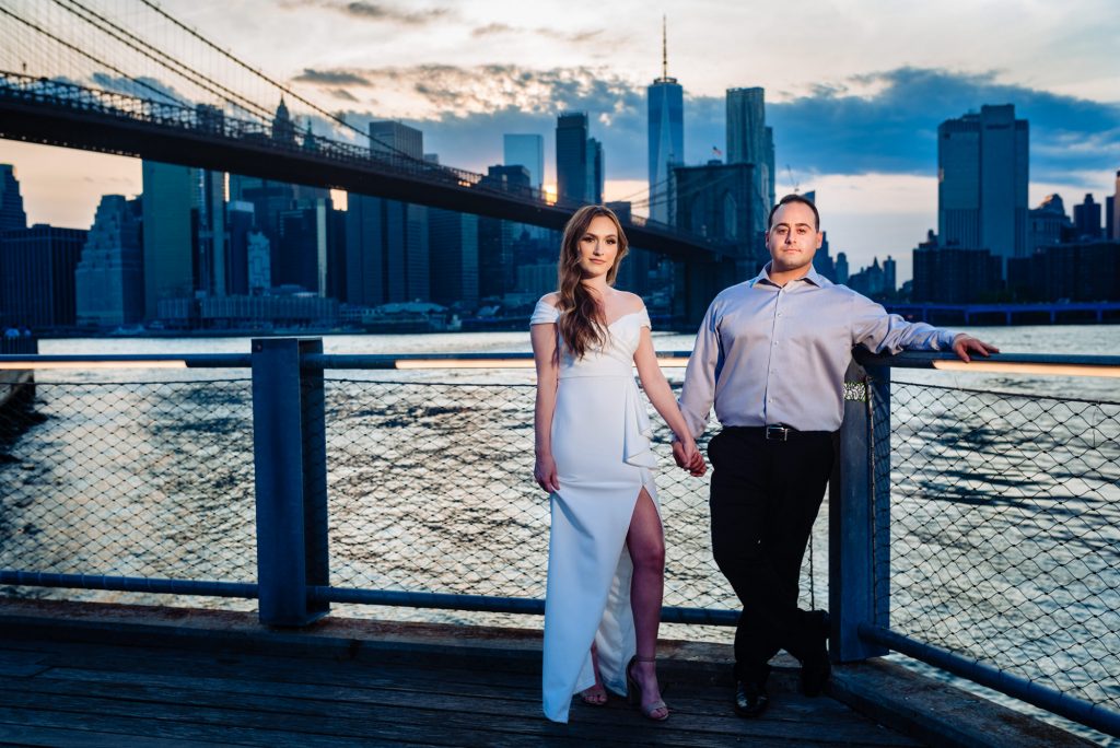couple taking a pose during their couple kisses for their Brooklyn Bridge park e-session