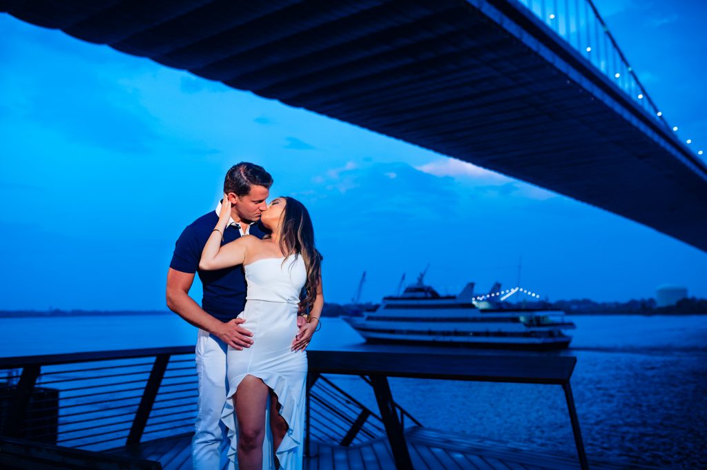 sunset photo of couple kissing under the bridge for their classic philly e-session