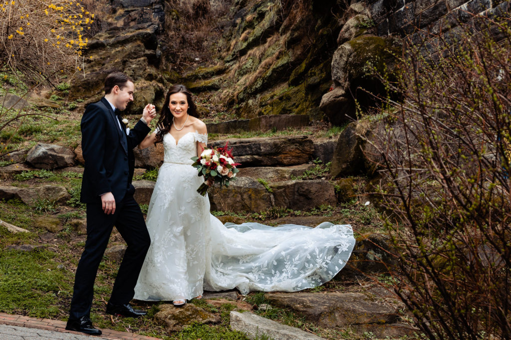 bride and groom taking a pose behind a rock stair during their wedding