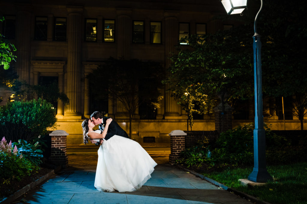 end of night shot of bride and groom kissing in the street