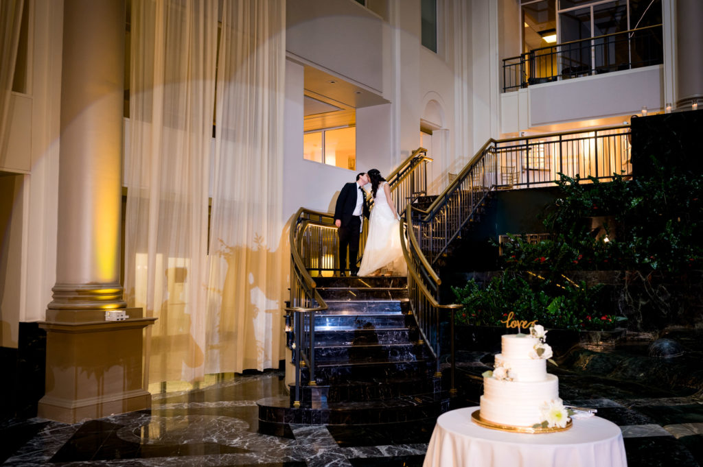 entrance of the bride and groom kissing on the stairs during their wedding reception