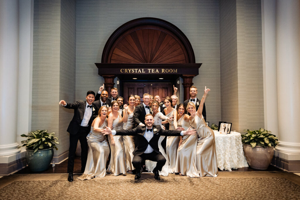 newlyweds with the bridesmaids and groomsmen posing outside the crystal tea room