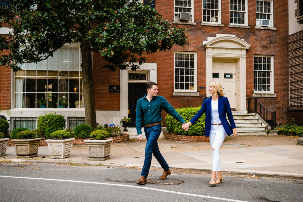 couple in their modern attire crossing a neighborhood street during their old city engagement shoot