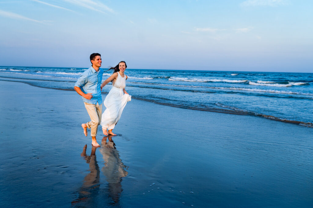 couple runs on the shoreline during their beach engagement shoot at new jersey