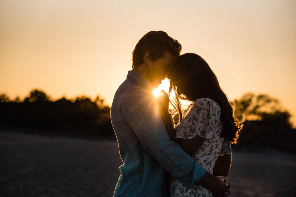 sunset shot of couple looking at each other during their margate beach engagement photoshoot