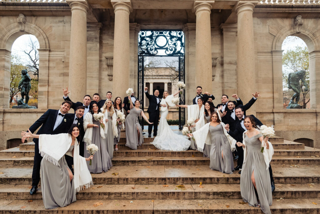 bride and groom with bridesmaids and groomsmen smiling for the camera
