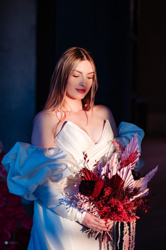 radiant bride carrying a red bouquet