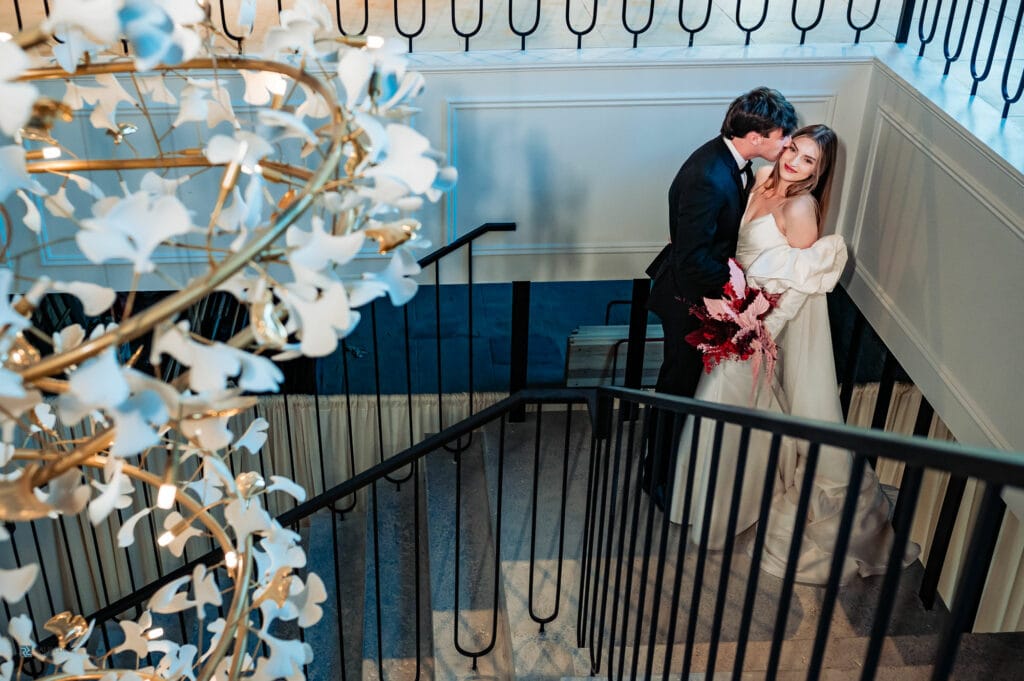couple is standing in a staircase while smiling for the camera