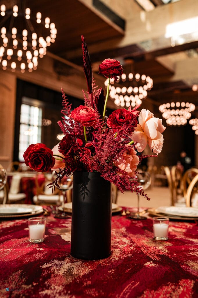 red florals compliment the red table cover of the wedding venue at the switch house