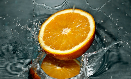 Orange slice splashing in water