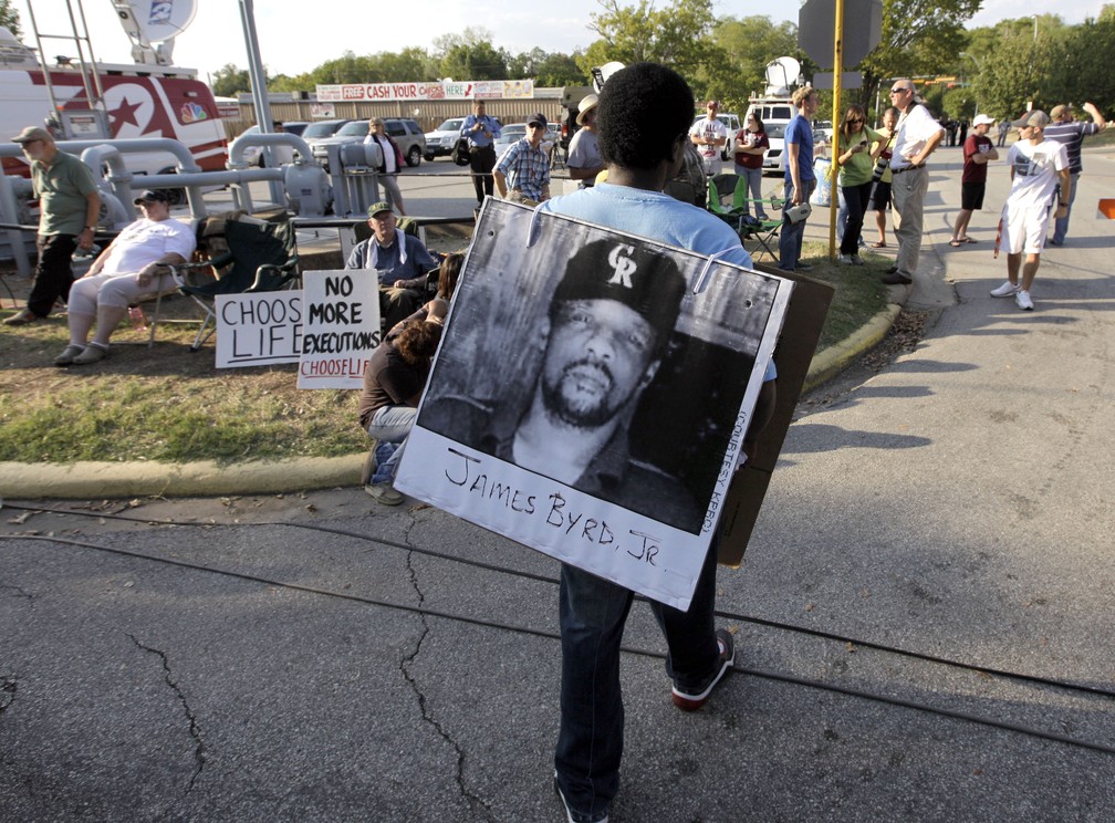 Manifestante usa cartaz com foto de James Byrd Jr., assassinado em 1998, em protesto em 2011 — Foto: David J. Phillip/AP Photo