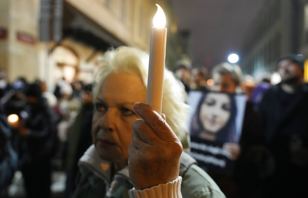 Mulher leva vela para protesto em Varsóvia neste sábado (6) contra leis restritivas contra o aborto após morte de grávida na Polônia — Foto: Czarek Sokolowski/AP Photo