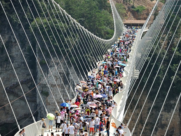 Imagem de 20 de agosto mostra visitantes inaugurando a ponte de vidro Zhangjiajie, na China (Foto: REUTERS/Stringer)