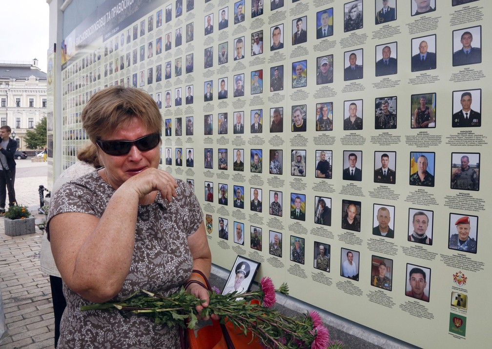 Imagem de 2017 mostra mulher que chora em um muro memorial com fotos de militares mortos no conflito com separatistas pró-russos no leste do país, em Kiev, na Ucrânia. O presidente ucraniano, Petro Poroshenko, disse que cerca de 10 mil pessoas, tanto militares como Civis, foram mortos na região de Donetsk desde 2014 — Foto: Efrem Lukatsky/AP