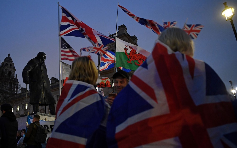 Apoiadores do Brexit agitam bandeiras do Reino Unido e do País de Gales perto da estátua de Winston Churchill, em Londres, no Dia do Brexit, na sexta-feira (31) — Foto: Daniel Leal-Olivas/AFP