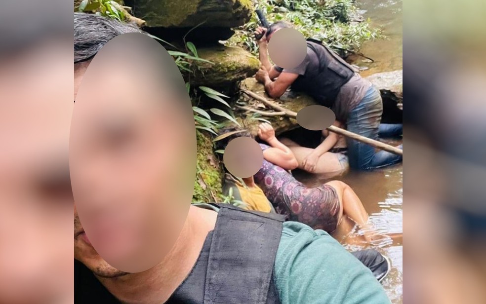 Família feita refém por Lázaro e dois policiais se escondem durante em córrego durante resgate, em Cocalzinho de Goiás — Foto: Reprodução/TV Anhanguera