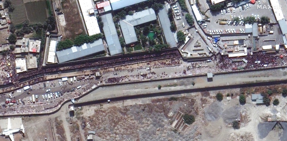 Imagem de satélite mostra uma multidão de pessoas ao longo da entrada leste do aeroporto internacional de Cabul na segunda-feira, 23 de agosto de 2021 — Foto: Maxar Technologies/AP