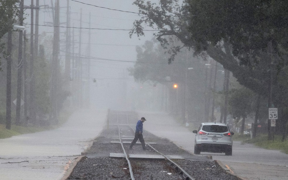 Homem é visto caminhando em meio às chuvas provocadas pelo furacão Delta em Lake Charles, na Louisiana, na sexta-feira (9) — Foto: ReutersAdrees Latif 