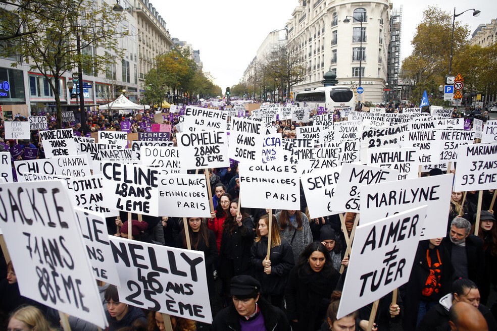 Manifestantes seguram cartazes com nome de vítimas de violência contra a mulher em Paris  — Foto: AP Photo/Thibault Camus