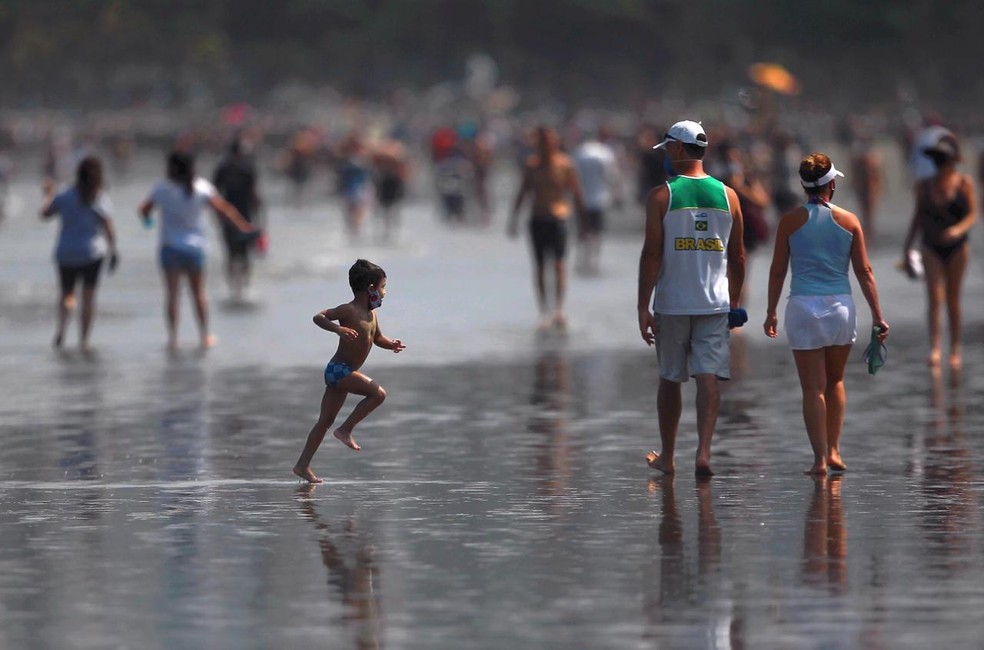 Criança brinca na faixa de areia da praia de Santos, SP, neste sábado (5) — Foto: Matheus Tagé/A Tribuna Jornal