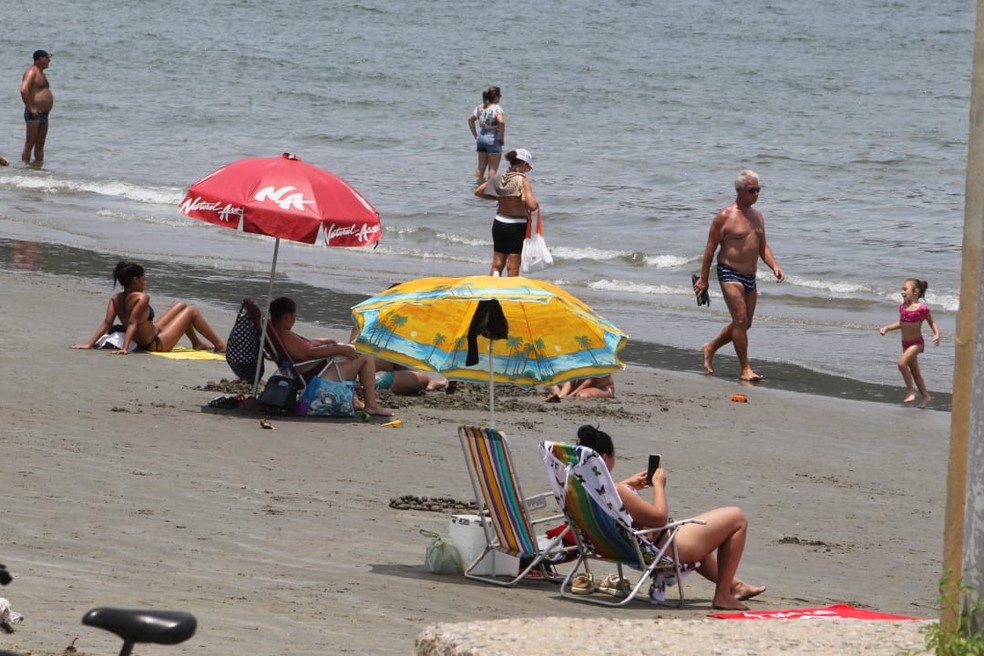 Banhista desrespeita proibição de guarda-sóis na faixa de areia da praia de Santos, SP — Foto: Carlos Nogueira/Jornal A Tribuna