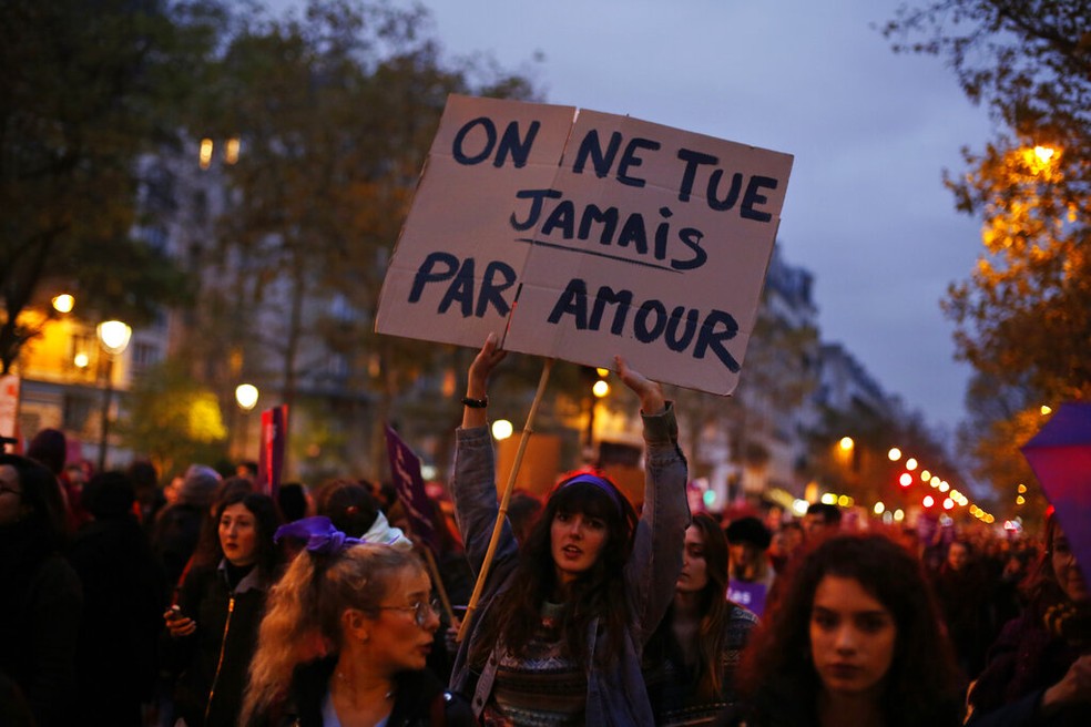 Mulher segura cartaz dizendo "Não se mata jamais por amor" em protesto na cidade de Paris neste sábado (23) — Foto: AP Foto/Thibault Camus