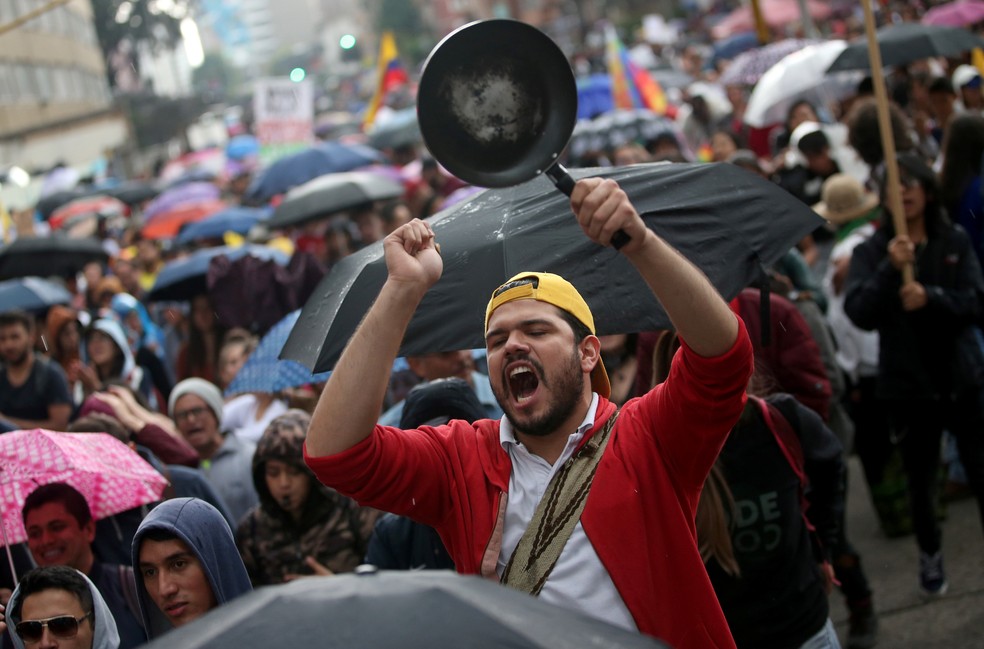 Um homem bate panela durante protesto combinado com shows musicais em Bogotá, na Colômbia, neste domingo (8) — Foto: Luisa Gonzalez/Reuters
