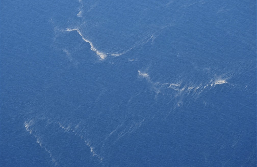 Foto aérea mostra manchas de óleo no local onde o submarino emitiu seu último sinal antes de desaparecer. Operação de busca se concentra no local. — Foto: Eric Ireng/AP