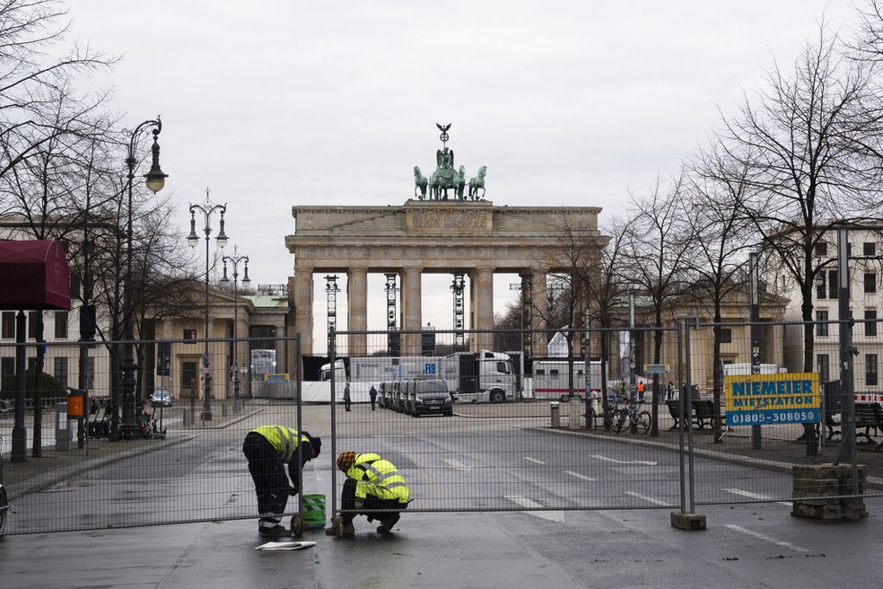 Na Alemanha, policiais cercam a área ao redor do Portão de Brandenburgo, marco de Berlim, na véspera do ano novo — Foto: Associated Press