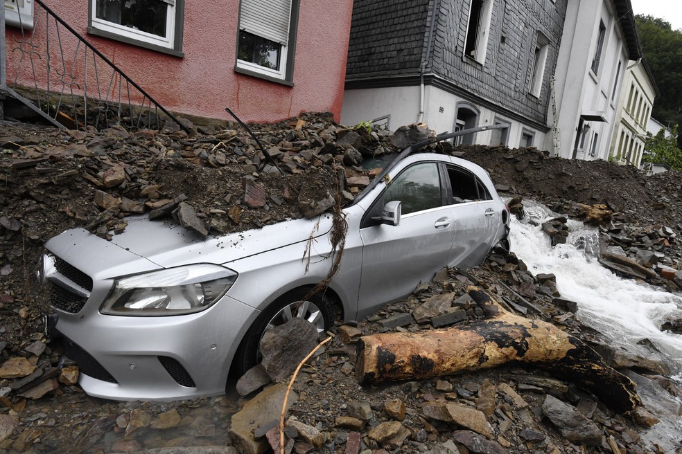 Carro coberto em Hagen, na Alemanha, com destroços arrastados pela enchente do rio Nahma em 15 de julho de 2021. Fortes chuvas transformaram o pequeno rio em uma torrente violenta. — Foto: Roberto Pfeil/DPA via AP