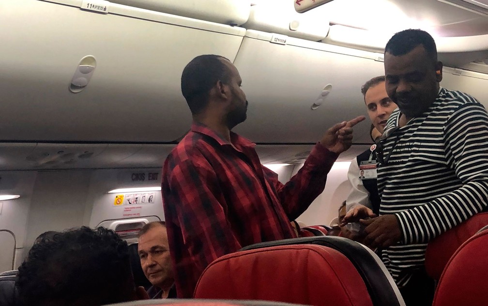 Homem (esquerda) confronta comissários de bordo e outros passageiros durante voo da Turkish Airlines entre Istambul e Cartum, na sexta-feira (14) — Foto: AP Photo/Hussein Malla