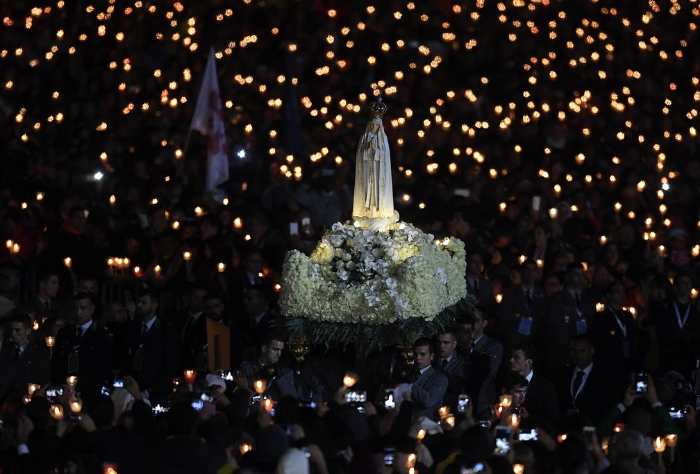 Fiéis carregam estátua da Virgem de Fétima nesta sexta-feira (12) durante visita papal (Foto: TIZIANA FABI / AFP)