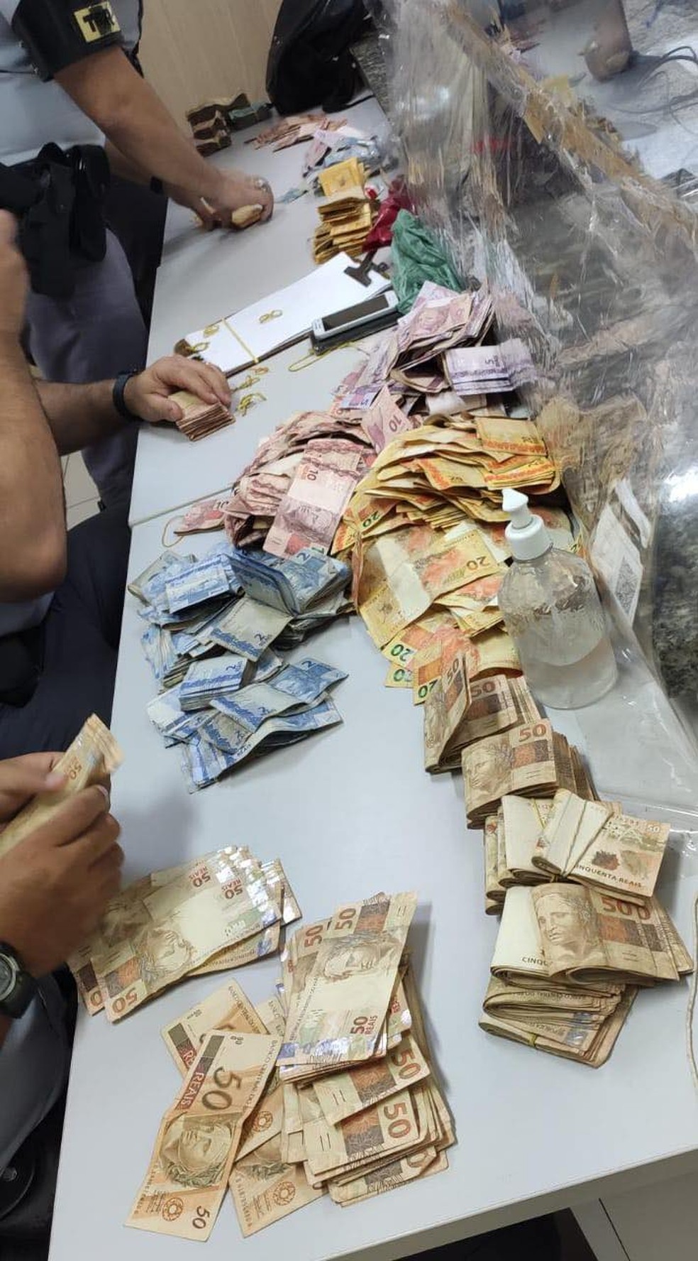 Policiais fizeram a contagem do dinheiro e apreensão resultou em R$ 73.026  — Foto: Polícia Rodoviária/Divulgação