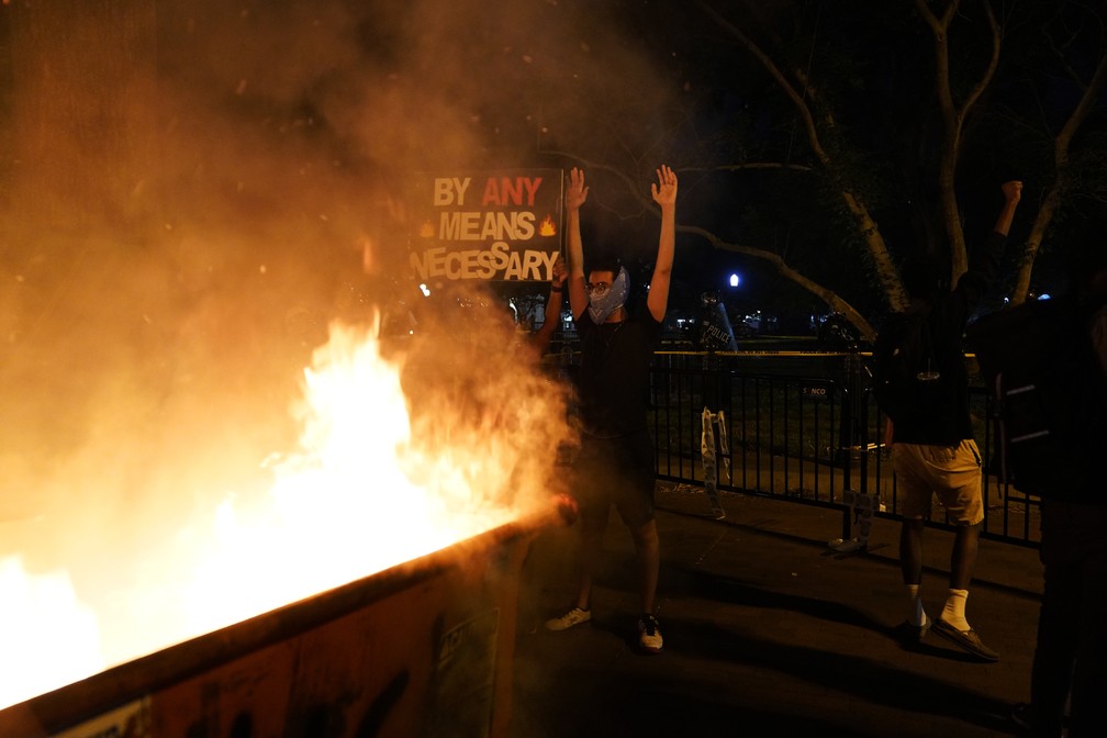 Manifestantes incendeiam caçamba de lixo em Washington, perto da Casa Branca, neste sábado (30) novo dia de protestos nos EUA — Foto: Evan Vucci/AP Photo