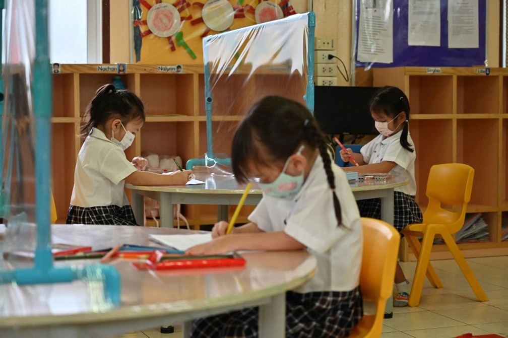 Alunos que frequentam sala de aula equipada com mesas com divisórias de plástico para impedir a propagação do novo coronavírus em escola em Bangkok, na Tailândia, em 17 de junho  — Foto: Romeo Gacad / AFP